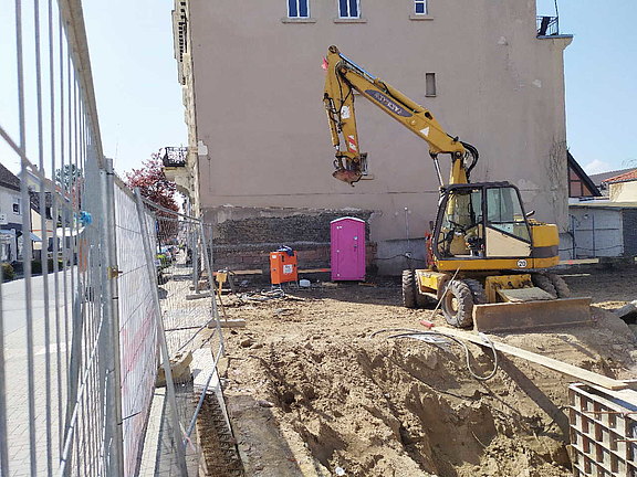 Blick auf die Baustelle vom 20. April 2021 Zu sehen ist die Baugrube mit Bagger.
