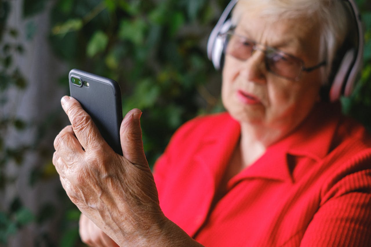 Das Bild zeigt eine ältere Frau mit Smartphone